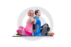 Happy young couple doing exercise in pair for pregnancy on the white background