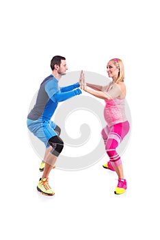 Happy young couple doing exercise in pair for pregnancy on the white background