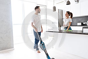 Happy young couple doing general clean at the kitchen