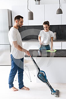 Happy young couple doing general clean at the kitchen