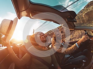 Happy young couple doing road trip in tropical city - Travel people having fun driving in trendy convertible car