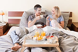 Happy young couple drinking coffee and orange juice