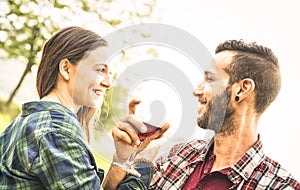 Happy young couple drinking red wine at vineyard farmhouse