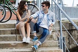 Happy young couple eating ice cream in the street.