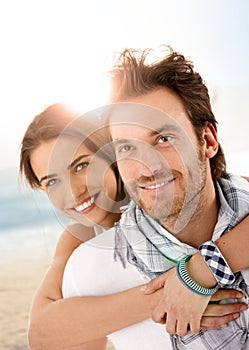 Happy young couple embracing on summer beach