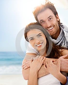 Happy young couple embracing on summer beach