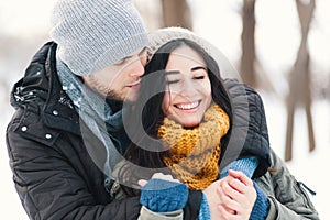 Happy young couple enjoying winter holidays smiling and hugging