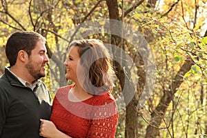 Happy, young couple in fall wooded area