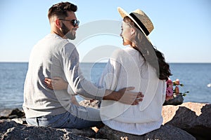 Happy young couple with flowers on beach. Honeymoon trip