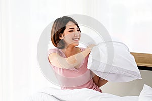 Happy young couple friend beautiful asia women having a pillow fight in their bedroom