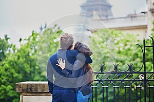 Happy young couple in front of the Eiffel tower