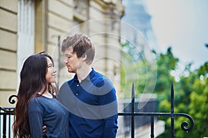 Happy young couple in front of the Eiffel tower