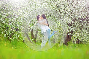 Happy young couple in the garden with apple flowers