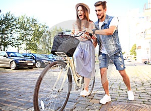 Happy young couple going for a bike ride on a summer day in the city.They are having fun together.