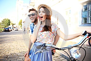 Happy young couple going for a bike ride on a summer day in the city.They are having fun together.