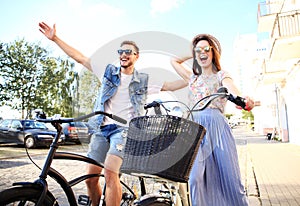 Happy young couple going for a bike ride on a summer day in the city.They are having fun together.