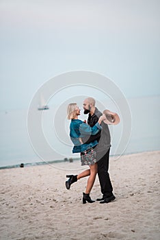 Happy young couple have fun on the beach, holding hands.