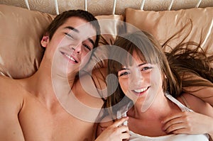 Happy young couple having fun on the bed
