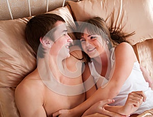 Happy young couple having fun on the bed