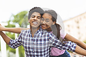 Happy young couple having fun and fooling around together outdoors