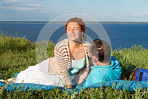 Happy young couple having fun outdoors and smiling. Beautiful couple laying on beach in the evening.