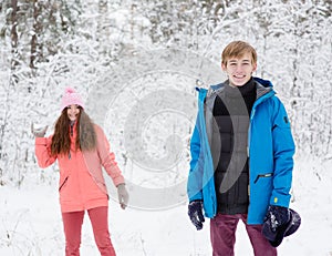 Happy young couple having fun together in snow in winter forest