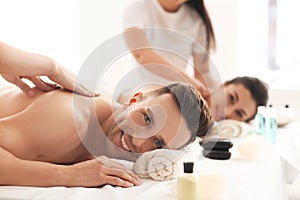 Happy young couple having massage in spa salon