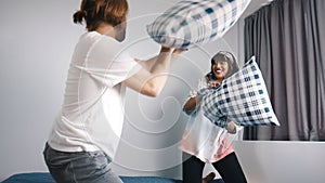 Happy young couple having pillows fight in the bedroom. Love and affection concept