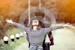 Happy young couple of hipsters riding a bicycle togetherp