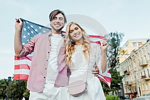 happy young couple holding american flag in hands Americas Independence