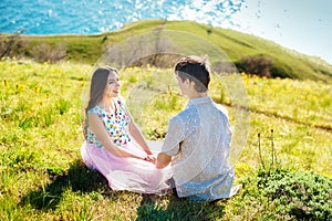 Happy young couple holding hands and laughing on the beach