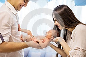 Happy young couple holding newborn baby boy