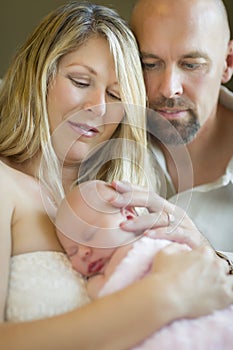 Happy Young Couple Holding Their Newborn Baby Girl