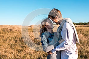 Happy young couple hugging and laughing outdoors.