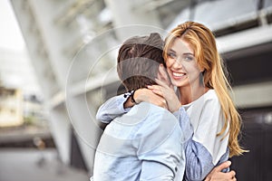 Happy young couple hugging and laughing outdoors.