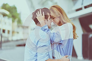 Happy young couple hugging and laughing outdoors.