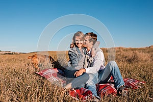 Happy young couple hugging and laughing outdoors.