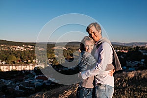 Happy young couple hugging and laughing outdoors.