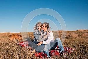 Happy young couple hugging and laughing outdoors.