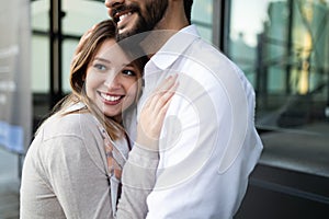Happy young couple hugging and laughing outdoors
