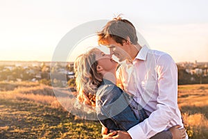 Happy young couple hugging and laughing outdoors.