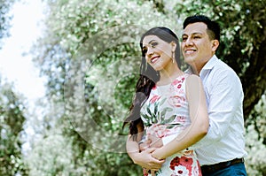 Happy young couple hugging and laughing outdoors.