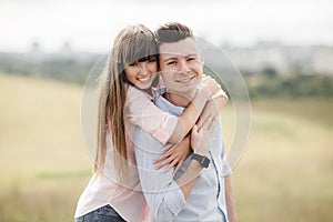 Happy young couple hugging and laughing outdoors. Love and tenderness. Lifestyle concept