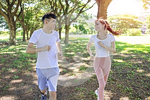 Happy young couple jogging in the  park on sunny day