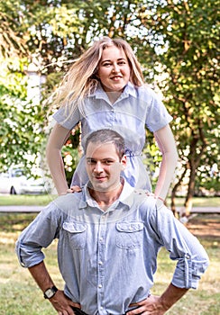 Happy young couple jumping and having fun outdoors in the park in a sunny summer day