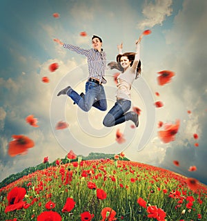 Happy young couple jumping in poppies field