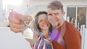 Happy young couple with keys to new home