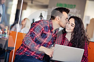 Happy young couple kissing in the office