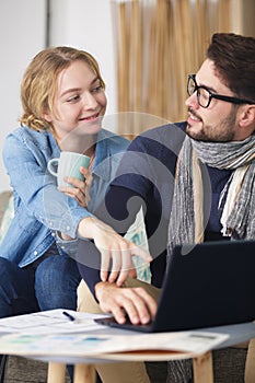 happy young couple with laptop at home
