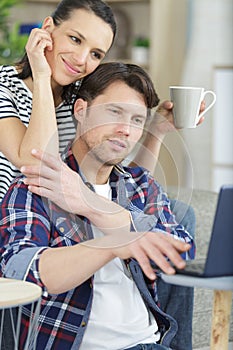 happy young couple with laptop in kitchen